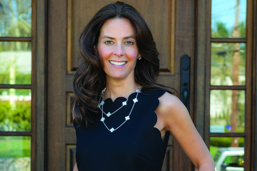 Jamie Genser standing in front of a home's front door
